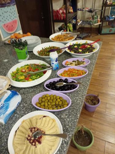 a table with many plates of food on it at Petra dorms inn in Petra