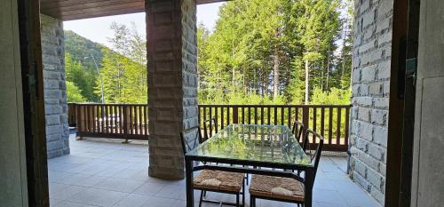 a patio with a glass table and chairs on a balcony at Bilocale nel Resort con terrazzo - Val di Luce in Abetone