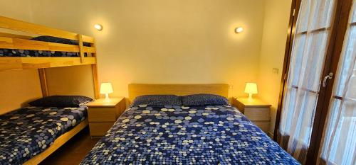 a bedroom with two bunk beds and two lamps at Bilocale nel Resort con terrazzo - Val di Luce in Abetone
