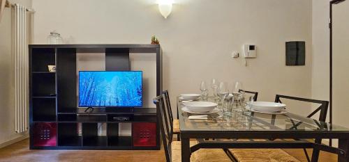 a dining room with a table and a television at Bilocale nel Resort con terrazzo - Val di Luce in Abetone