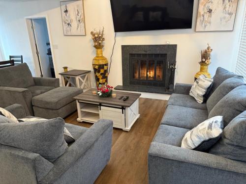 ein Wohnzimmer mit zwei Sofas und einem Kamin in der Unterkunft POCONOS everything close to Luxury vacational home in the heart of poconos with 3 outdoor pools for the public of the Tobyhanna community in Tobyhanna