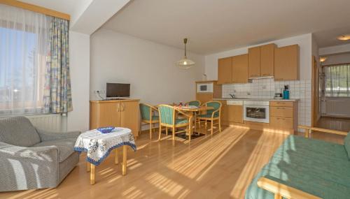 a living room with a kitchen and a dining room at Haus Schluder - Familie Stanitzer in Weissensee