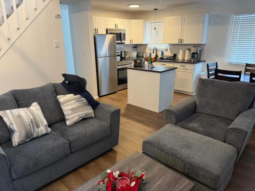 ein Wohnzimmer mit Couch und Küche in der Unterkunft POCONOS everything close to Luxury vacational home in the heart of poconos with 3 outdoor pools for the public of the Tobyhanna community in Tobyhanna