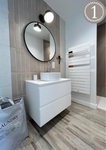 une salle de bain avec un lavabo blanc et un miroir dans l'établissement Le 70 Sainte Marine, à Combrit