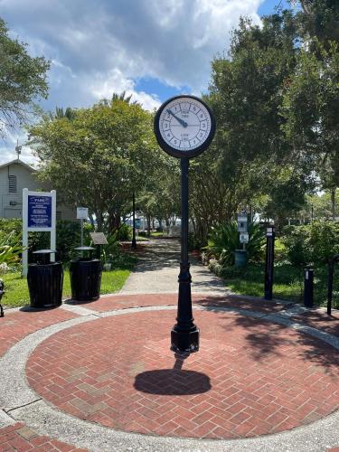 a clock on a pole on a brick sidewalk at 100 Commander in Saint Marys