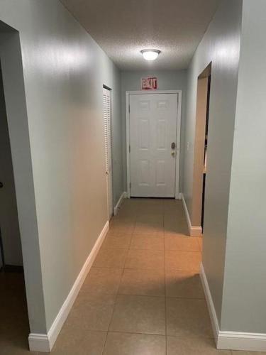 a hallway with a white door and a tile floor at 100 Commander in Saint Marys