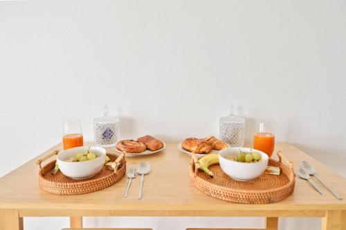 - une table avec du pain et des bols de fruits et de jus dans l'établissement Retraite Romantique à Étampes, à Étampes