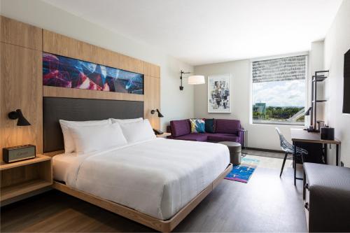a hotel room with a large bed and a couch at Aloft San Juan in San Juan