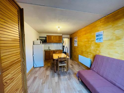 Il comprend un salon avec un canapé violet et une cuisine. dans l'établissement Studio cabine, aux Angles