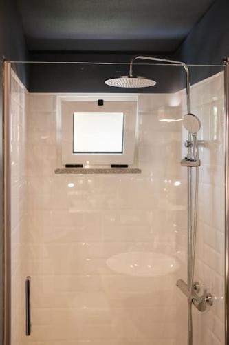 a bathroom with a shower with a tv on the ceiling at BABhouse Villa Jardim das Laranjeiras in Nagoselo do Douro