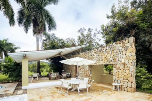 アナポイマにあるSpacious 5BR Villa at Mesa de Yeguasの石壁のパティオ(テーブル、椅子付)