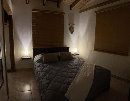 a bedroom with a bed and two lights on two tables at La Casita Amarilla en Utuado, Puerto Rico in Utuado