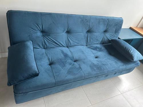 a blue couch with two pillows on it at Flat Boa Viagem -500 m praia - Golden Style in Recife