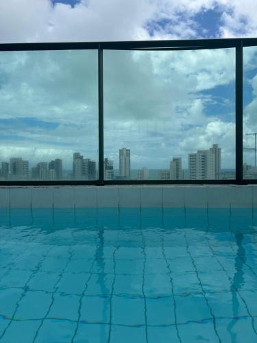 a swimming pool with a view of the city at Flat Boa Viagem -500 m praia - Golden Style in Recife