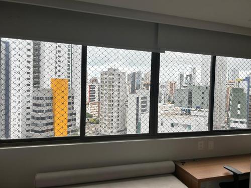 a view of a city skyline from a window at Flat Boa Viagem -500 m praia - Golden Style in Recife