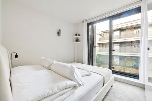 a white room with a couch and a large window at Delightful Tower Bridge Apartment Sleeps 6 in London