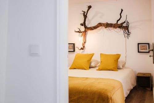 a bedroom with a bed with yellow pillows at BABhouse Casa D'ouro in Nagoselo do Douro