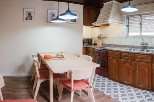 a kitchen with a white table and chairs in a room at BABhouse Casa D'ouro in Nagoselo do Douro