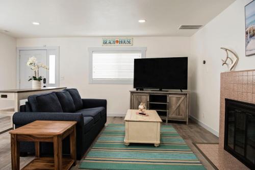 a living room with a couch and a flat screen tv at Seaside Retreat Hot Tub Steps to Beach Slps 6 in Seaside