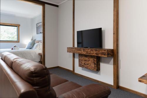 a living room with a couch and a television at Mount Mee Country Lodge in Mount Mee