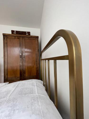 a bed with a wooden cabinet in a room at Apartmán Bellevue in Boskovice