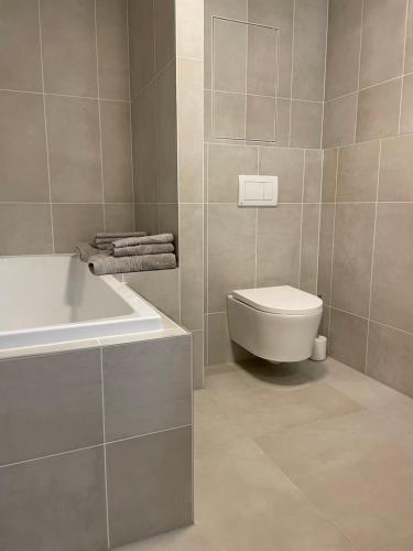 a bathroom with a tub and a toilet and a sink at Apartmán Bellevue in Boskovice