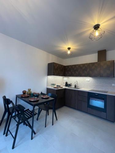 a kitchen with a table and chairs and a kitchen with a sink at Apartmán Bellevue in Boskovice