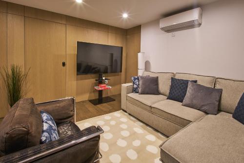 a living room with a couch and a flat screen tv at Modern 2 Bedroom Retreat in Downtown Manhattan in New York