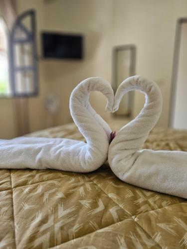 two swans shaped like hearts laying on a bed at Blue Moon Hostel in Antigua Guatemala