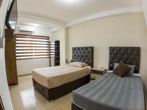 una camera con 2 letti e un letto Sidx Sidx Sidx Sidx Sidx di Ubicación Ideal departamento en Santa Cruz a Santa Cruz de la Sierra