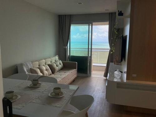 a living room with a couch and a table at Paraíso Azul em Ponta Negra, Natal RN in Natal