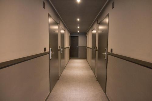 a corridor of stalls in an office building with a row of elevators at Hotel Iam in Suncheon
