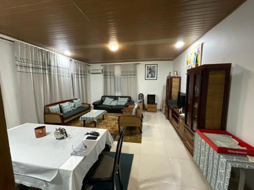a living room with a table and a couch at Appartement luxueux Ngousso Yaoundé in Yaoundé
