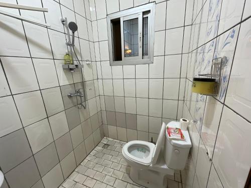 a small bathroom with a toilet and a window at Appartement luxueux Ngousso Yaoundé in Yaoundé