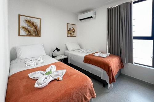 a hotel room with two beds with towels on them at Flat Genebra Bessa 2 Quartos 4 Pessoas 150m Praia in Tambaú