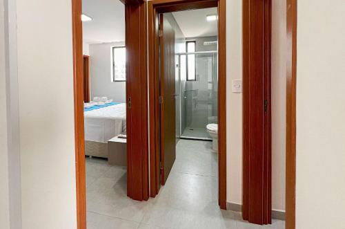 a bathroom with a door leading to a bedroom at Flat Genebra Bessa 2 Quartos 4 Pessoas 150m Praia in Tambaú