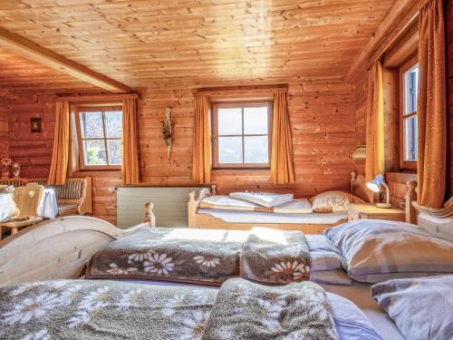 a bedroom with three beds in a wooden cabin at Grabnerhof in Brixen im Thale