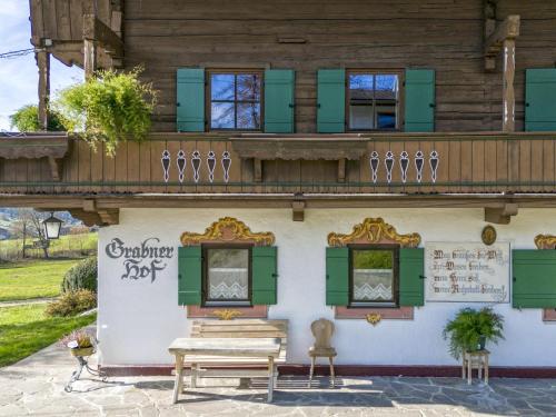 a building with green shutters and a balcony at Grabnerhof in Brixen im Thale