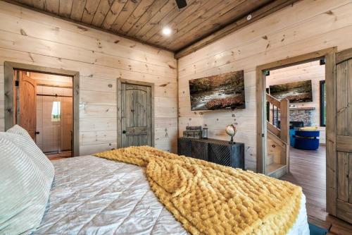 a bedroom with a large bed in a room with wooden walls at New Explorer's Hideaway,Mtn View, Firepit,Upscale in Sevierville