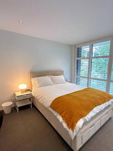 a white bedroom with a large bed and a window at Modern Loft Retreat in Barton Canberra ACT near Parliament House in Barton