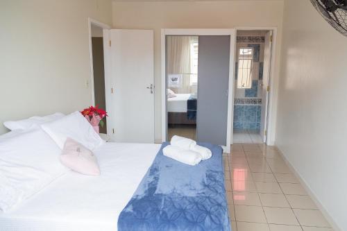 a bedroom with a white bed with towels on it at Conforto em local privilegiado in Itajaí