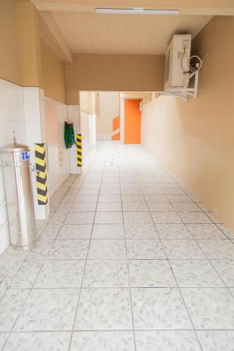 an empty hallway in a building with a tile floor at Conforto em local privilegiado in Itajaí