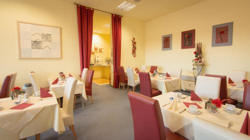 a restaurant with tables and chairs with white tablecloths at Excelsior Bochum in Bochum