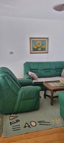 a living room with a green couch and a table at Kraljevi Konaci Olja in Zlatibor