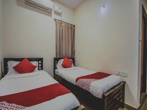two beds in a room with red and white sheets at Hotel O Grand Brundavan in Hyderabad