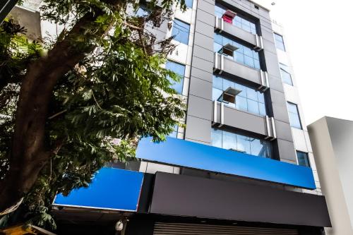 SecunderābādHotel O Grand Brundavan的公寓大楼拥有蓝色的窗户和一棵树