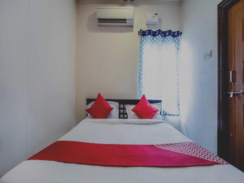 a bedroom with a bed with red and white at Hotel O Grand Brundavan in Hyderabad