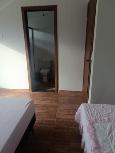 a bedroom with a bathroom with a toilet and a mirror at Estância da Mata, Brasil in Lapinha
