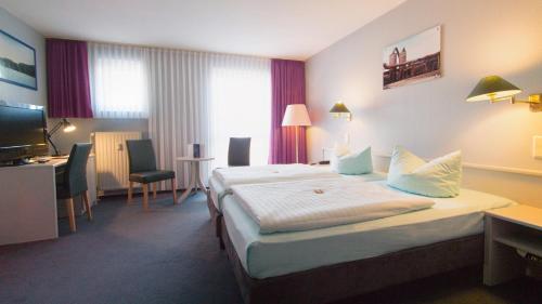 a hotel room with a bed and a desk at Excelsior Bochum in Bochum