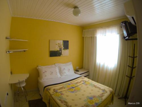 a small bedroom with a bed and a window at Pousada UpSerra in Urubici
